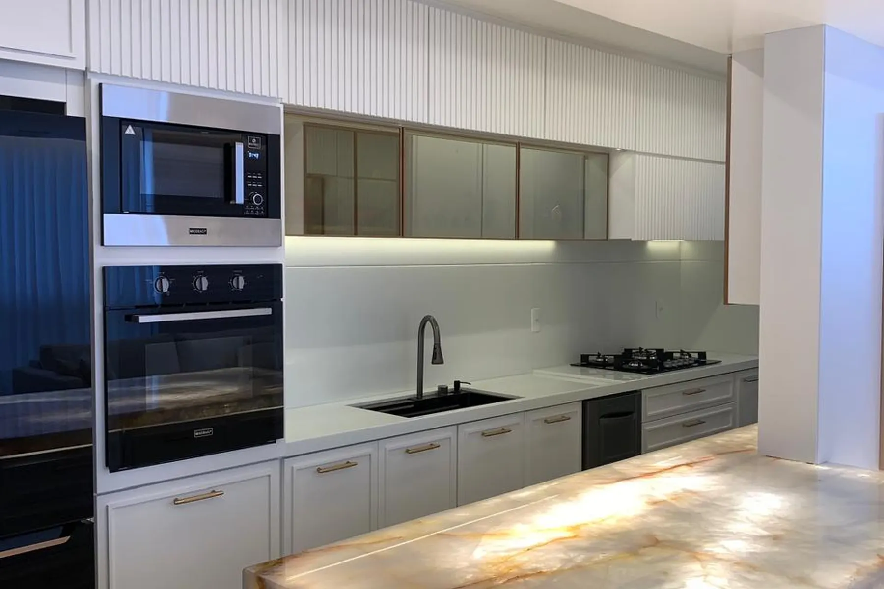 Cozinha de alto padrão com ilha em ônix retroiluminado executada pela BM Rochas em Vila Velha