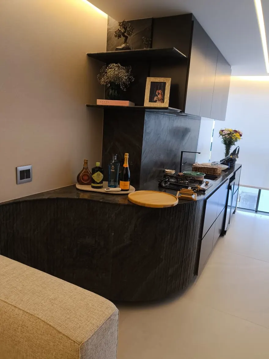 Área gourmet com bancada curva em mármore escuro executada pela BM Rochas